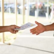 Man handing another man a paper for his Hawaii business. Hawaii SEO and Web Design helps businesses extend their exposure to new Hawaii customers using Local SEO